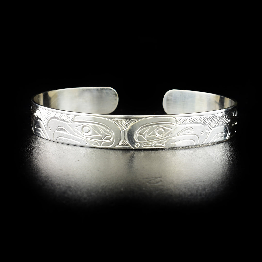 Double eagle bracelet hand-carved by Kwakwaka'wakw artist Don Lancaster. Made of sterling silver. Bracelet is 6.60" long with 0.60" gap and has width of 0.38".