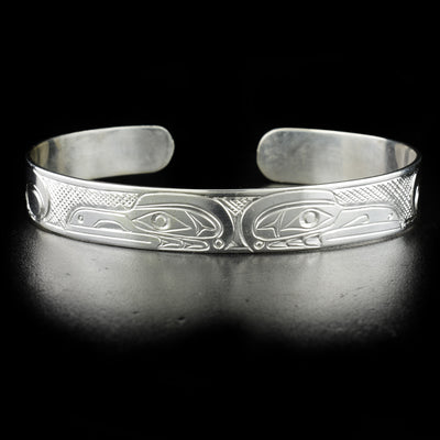 Double raven bracelet hand-carved by Kwakwaka'wakw artist Don Lancaster. Made of sterling silver. Bracelet is 6.55" long with 0.60" gap and has width of 0.38".