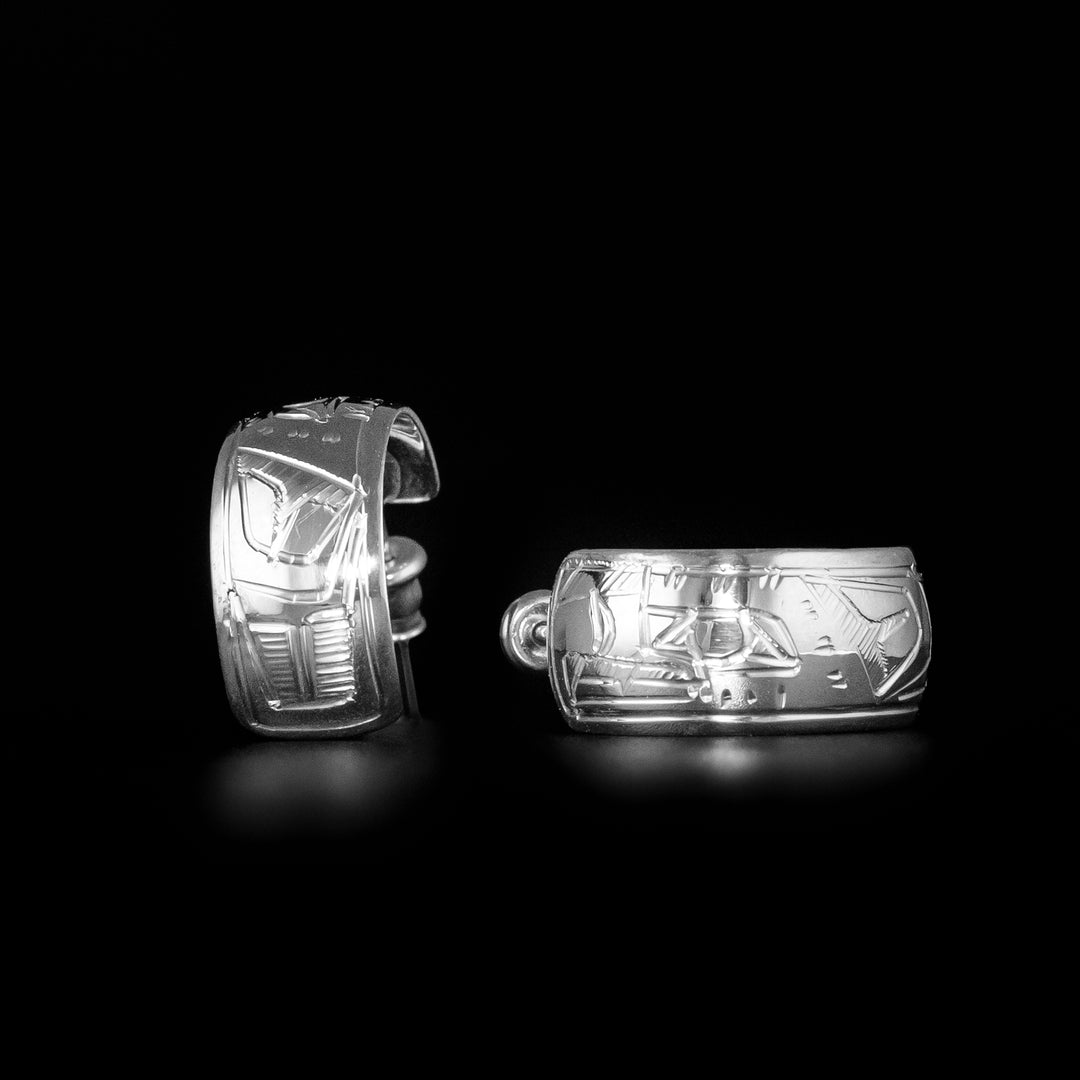 These unique stud hoop earrings are made from sterling silver and have wide bands curved into hoops with a gap in the back. There are depictions of the Eagle carved into the surface of the band.