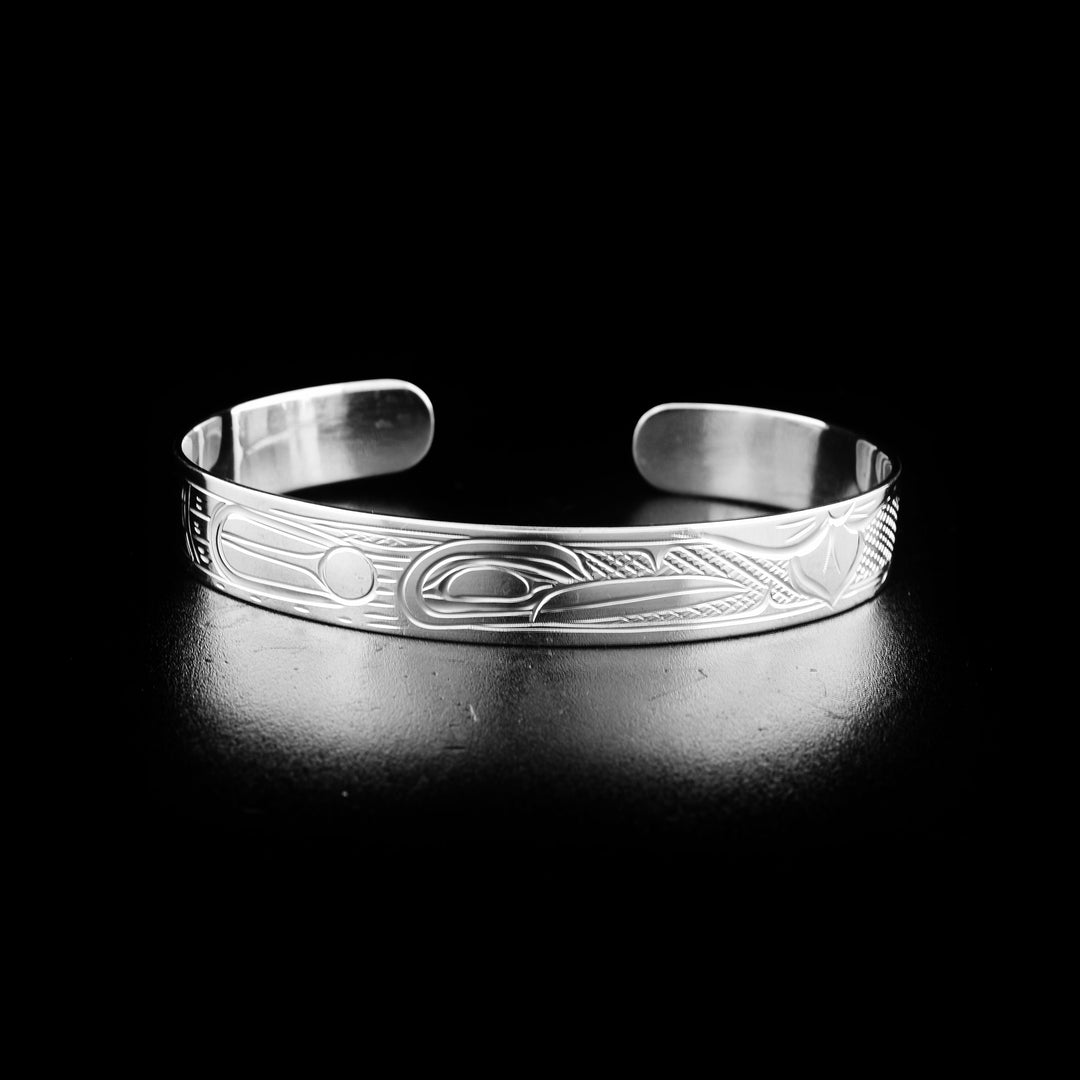 This Hummingbird bracelet is made from sterling silver and has a thin band with a gap in the back. There is a depiction of the Hummingbird carved into the surface of the band.