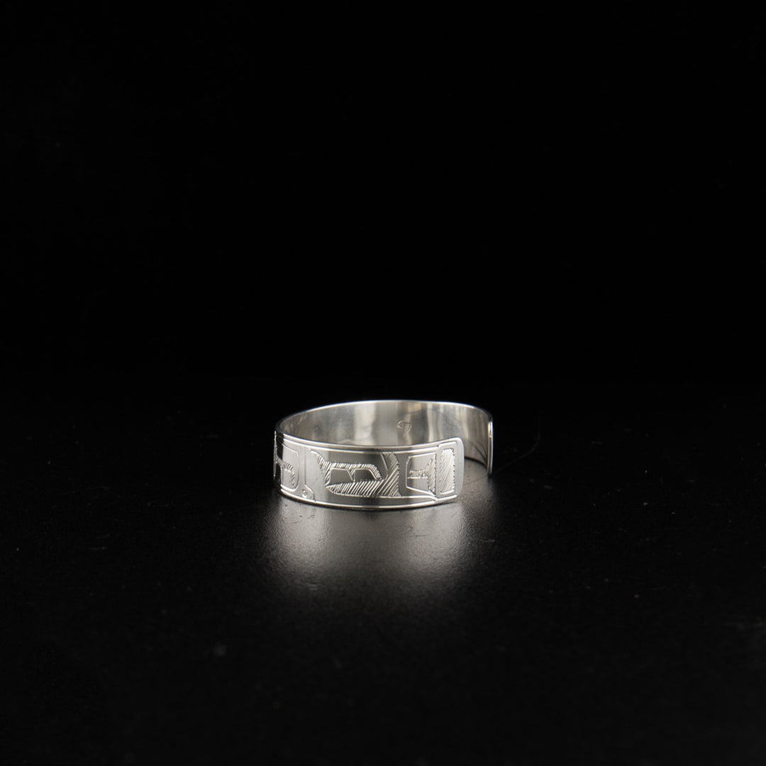 Sterling silver orca baby bracelet hand-carved by Coast Salish artist Gilbert Pat. 4.13" long with 0.63" gap. 0.38" wide.