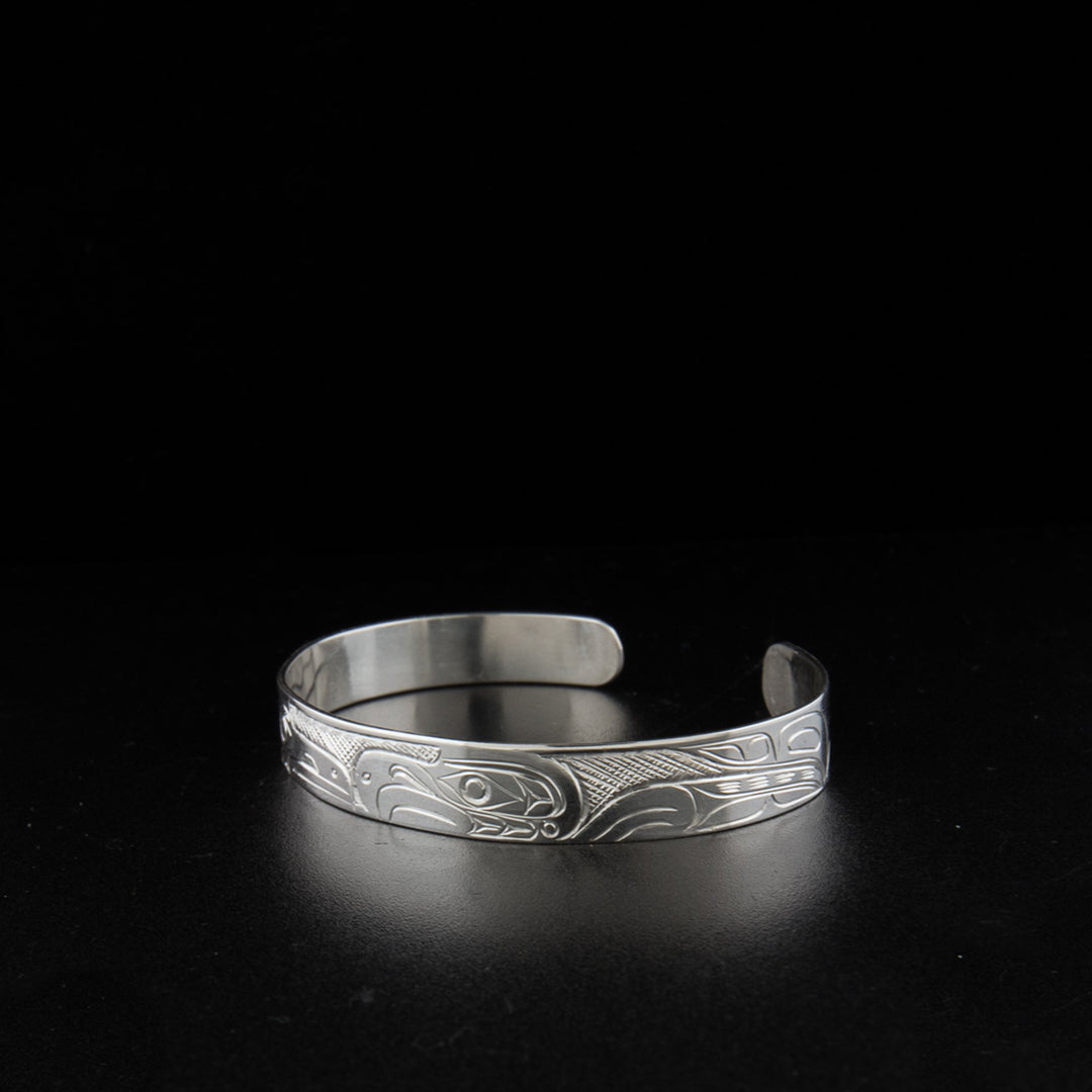Sterling silver raven and eagle bracelet hand-carved by Kwakwaka'wakw artist Don Lancaster. 6.63" long with 0.88" gap. 0.38" wide.