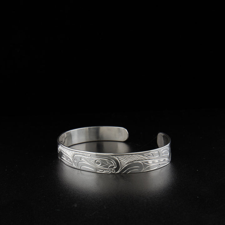 Sterling silver raven and eagle bracelet hand-carved by Kwakwaka'wakw artist Don Lancaster. 6.63" long with 0.88" gap. 0.38" wide.