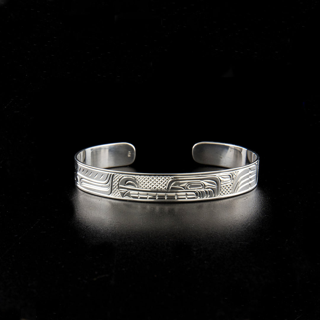 Sterling silver wolf bracelet hand-carved by Kwakwaka'wakw artist Charles Harper. 6.25" long with 1" gap. 0.38" wide.