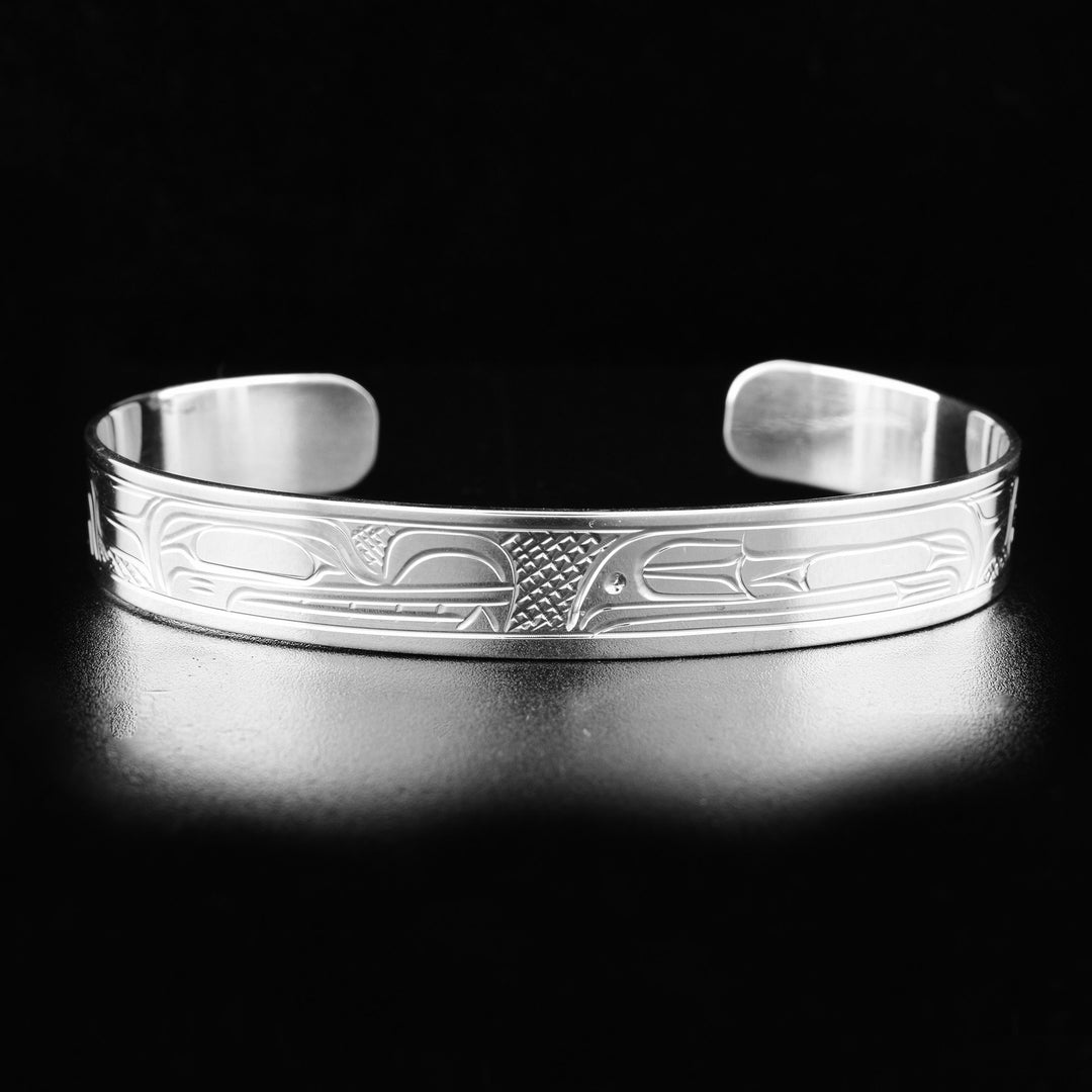 This Raven and Wolf bracelet cuff is made from sterling silver and has a single band with a gap in the back. There are gorgeous depictions of the Wolf and the Raven carved into the surface of the band.