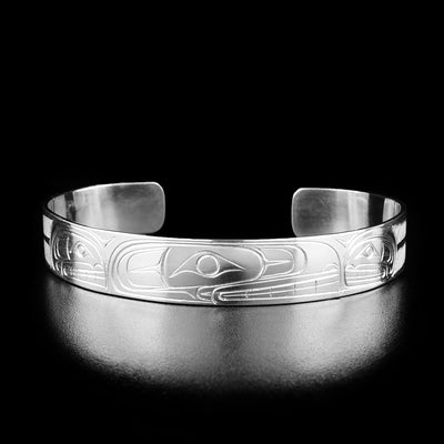 This orca bracelet has the profile of an orca's head with teeth showing in the center of the bracelet, facing the right. On either side are two smaller orcas.