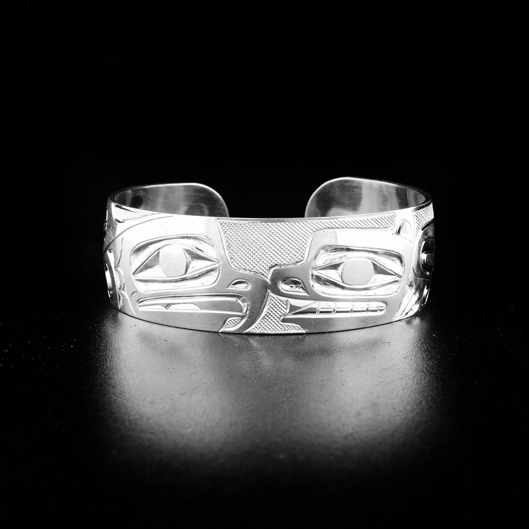Eagle and bear bracelet hand-carved by indigenous artist Ivan Thomas. Made of sterling silver. Bracelet is 6.3" long with 0.6" gap and has width of 0.75".
