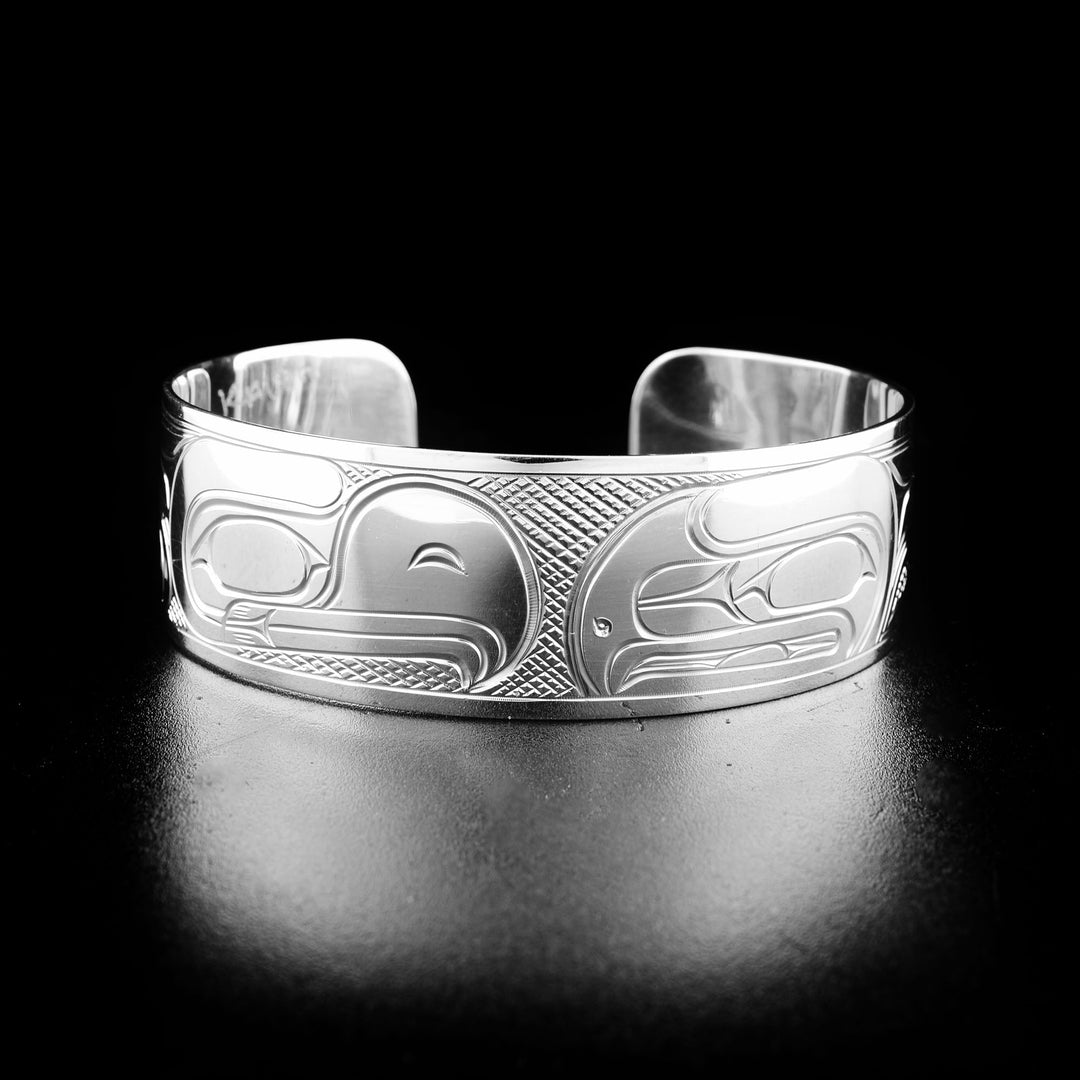 Sterling silver eagle and raven bracelet hand-carved by Kwakwaka'wakw artist Victoria Harper. Bracelet is 6.25" long with 0.81" gap and is 0.75" wide.