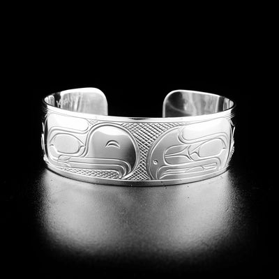 Sterling silver eagle and raven bracelet hand-carved by Kwakwaka'wakw artist Victoria Harper. Bracelet is 6.25" long with 0.81" gap and is 0.75" wide.