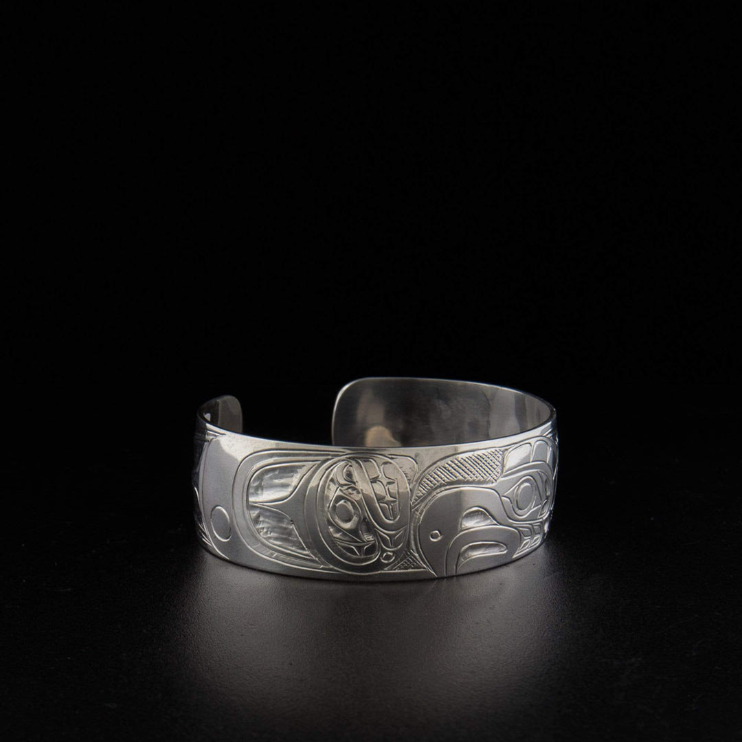 Sterling silver thunderbird and orca bracelet hand-carved by Kwakwaka'wakw artist Don Lancaster. 6.19" long with 0.75" gap. 0.75" wide.