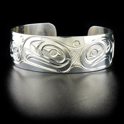 Unique "We are All Connected" cuff bracelet hand-carved by Kwakwaka'wakw artist Paddy Seaweed. Features an eagle, an orca, a raven, a salmon and a trout. Made of sterling silver. Bracelet is 6.3" long with 0.8" gap and has width of 0.8".