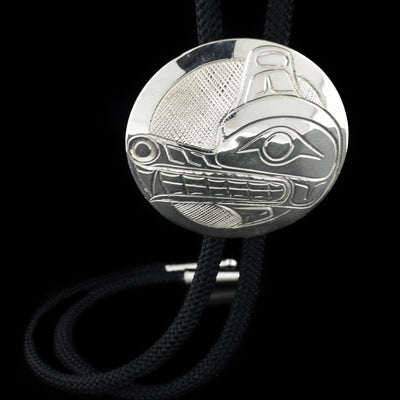 Wolf bolo tie hand-carved by Kwakwaka'wakw artist Norman Seaweed. Slide is made of sterling silver. Cord is 35" long and round slide is 2" in diameter.