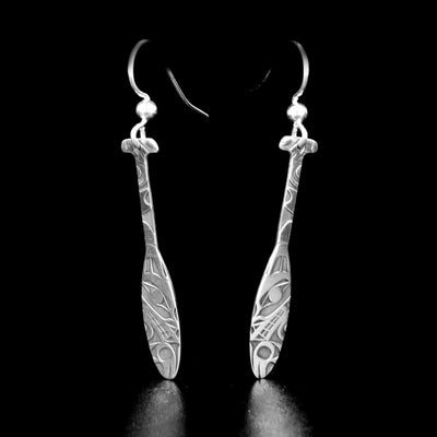 Stunning wolf paddle earrings by Tahltan artist Grant Pauls. Made of sterling silver. Each earring measures 1.95" x 0.25" including hook.
