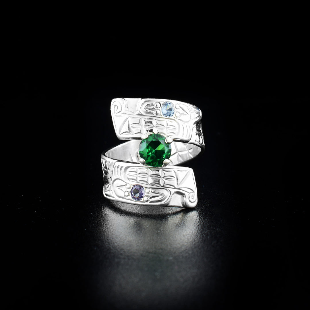 Wolf wrap ring hand-carved by Coast Salish and Cree artist Richard Lang. Made of sterling silver and lab-grown stones in purple, blue and green. Band is 0.31" wide, with the flexible wrap design giving the ring a comfortable fit. Size 7.5.