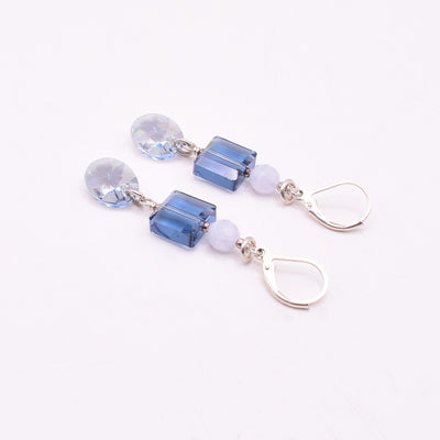 Dazzling lever back earrings handcrafted by artist Karley Smith. Made of sterling silver, Swarovski Crystal and blue lace agate. Ear hooks are sterling silver. Each earring measures 2.15" x 0.40" including hook.