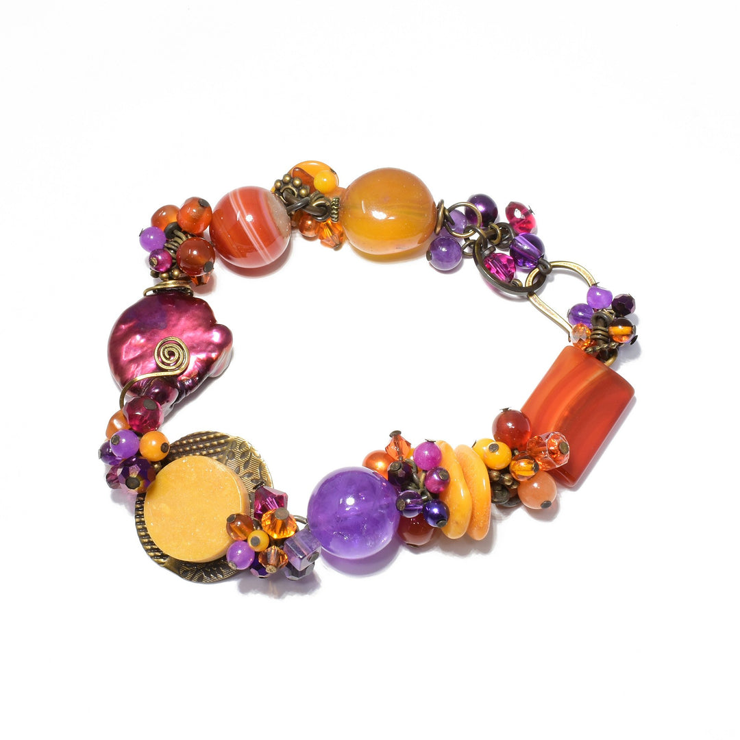 This unique crystal bead bracelet is made from  amber, amethyst, glass, pearls, carnelian agate, Austrian crystal, dyed jade, mother of pearl and chalcedony. This bracelet has beads made from all those material and each of the beads has a unique shape, design and material.