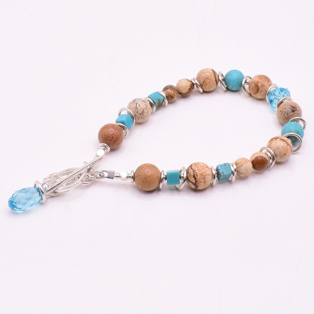 Turquoise Landscape Jasper Bracelet handcrafted by artist Karley Smith. Made of landscape jasper, Swarovski Crystal, turquoise and sterling silver. The bracelet closes with a toggle clasp and a safety chain adds an extra element of security. Bracelet is 7.50" long when clasped shut.