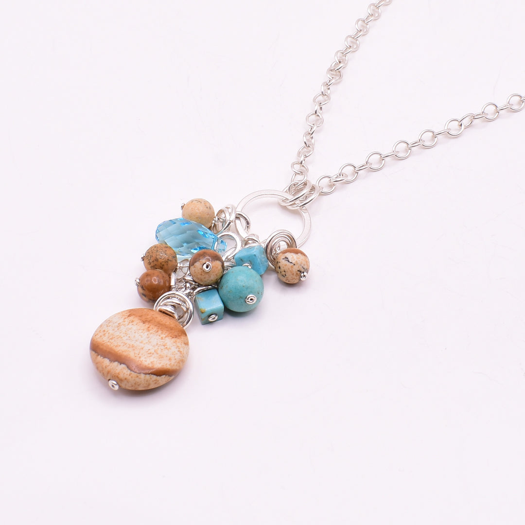 Turquoise and Landscape Jasper Cluster Pendant Necklace handcrafted by artist Karley Smith. Pendant made of sterling silver, turquoise and landscape jasper. Sterling silver chain included. Pendant measures 1.95" x 0.65" including bails and chain is 20" long.