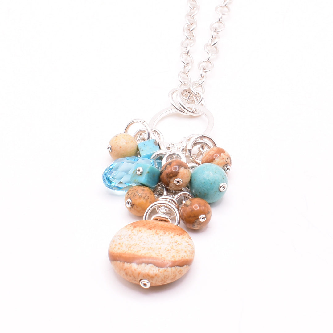 Turquoise and Landscape Jasper Cluster Pendant Necklace handcrafted by artist Karley Smith. Pendant made of sterling silver, turquoise and landscape jasper. Sterling silver chain included. Pendant measures 1.95" x 0.65" including bails and chain is 20" long.