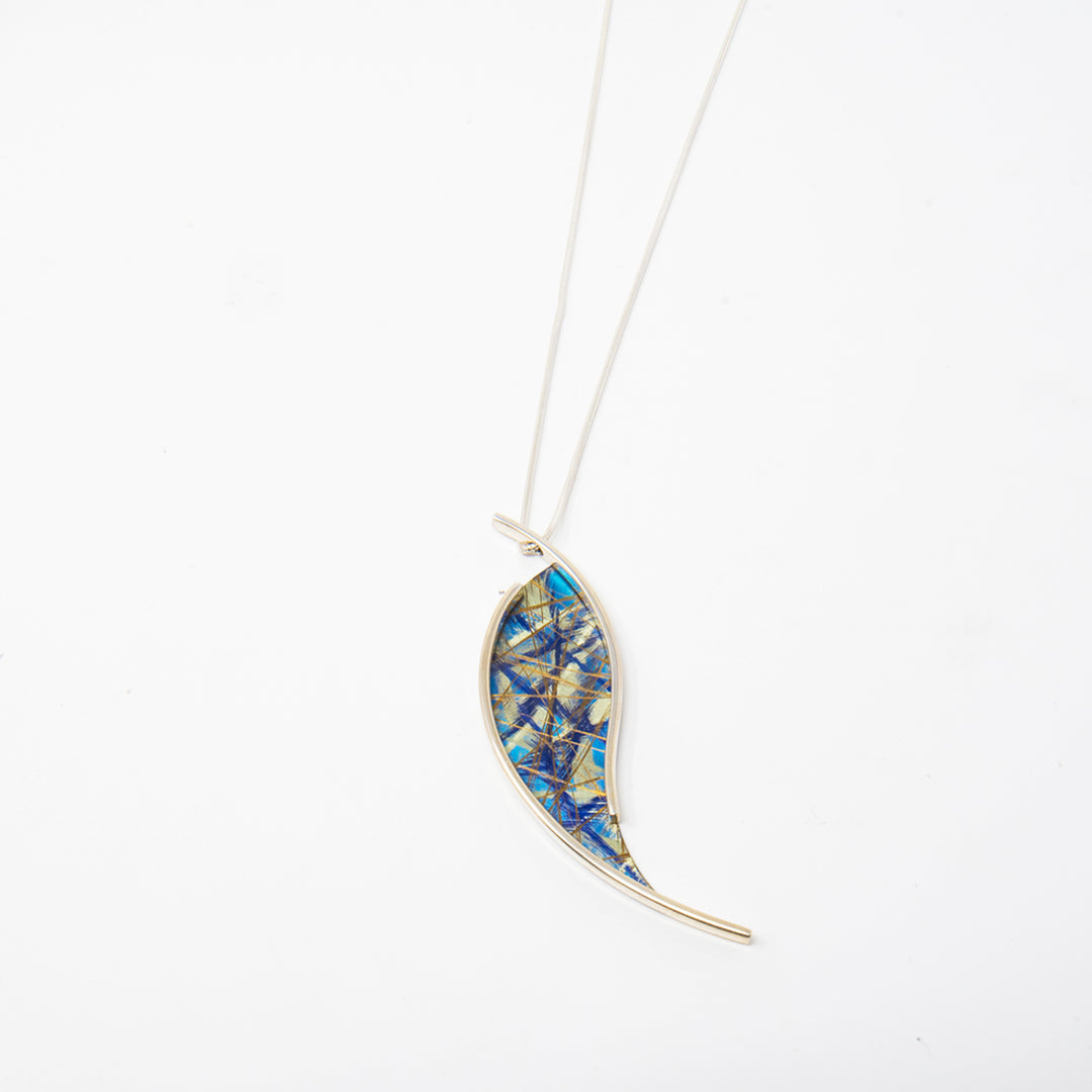 This titanium necklace is made from anodized titanium and sterling silver and has a teardrop shaped pendant. The teardrop is made from titanium and has an array of colorful designs that are achieved by anodizing the metal. There is a sterling silver wire running along and past the piece, giving is an elegant look.. 
