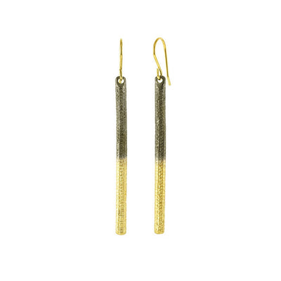 Two-Tone Textured Bar Dangle Earrings handcrafted by artist Dushka Vujovic. Made of oxidized sterling silver and 18K gold plating. Each earring measures 2.50" x 0.13" including hook.
