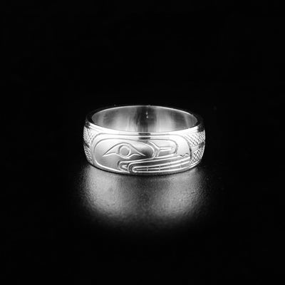 This orca ring has the profile of an orca's head facing the right. The are hand carved designs on both sides of the ring representing the orca's body and fins.