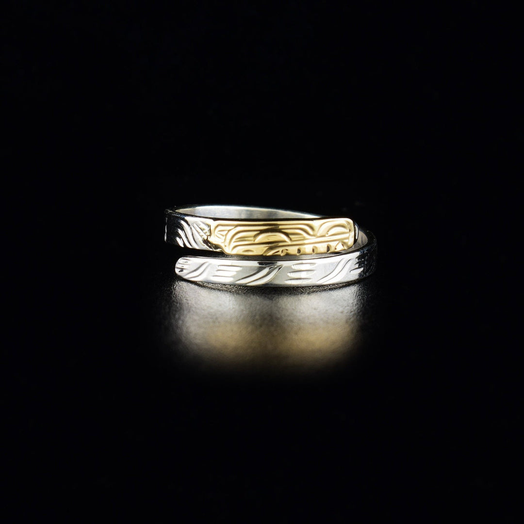 This silver Wolf ring is made from 14K gold and sterling silver. It has a very thin band that wraps around the finger twice. There is a depiction of the Wolf carved into the surface of the band and the face is made from 14K gold.