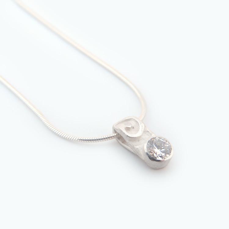 This peridot pendant necklace is made from sterling silver and peridot gemstone. There is a swirly design above the gemstone which is faceted in the bottom of the pendant.